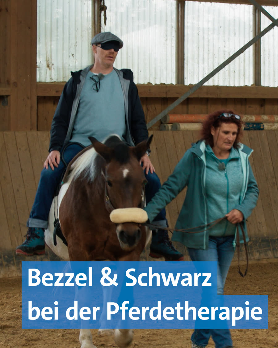 Videovorschau: Ein Mann reitet in der Reithalle, eine Mitarbeiterin führt das Pferd am Strick. Eingeblendeter Titel: „Bezzel & Schwarz bei der Pferdetherapie“.